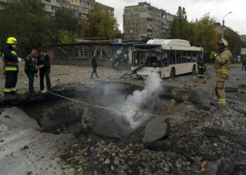 Bomberos y agentes de la policía trabajan en el sitio donde una explosión creó un cráter en una calle tras un ataque ruso en Dnipro, Ucrania. Foto: AP/Leo Correa
